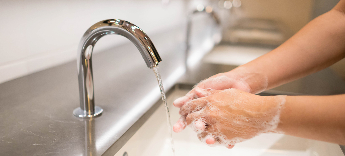 Closeup woman washing hand with soap and running water for coronavirus protection