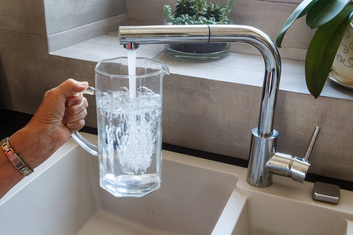 To fill a jug with tap water at the sink