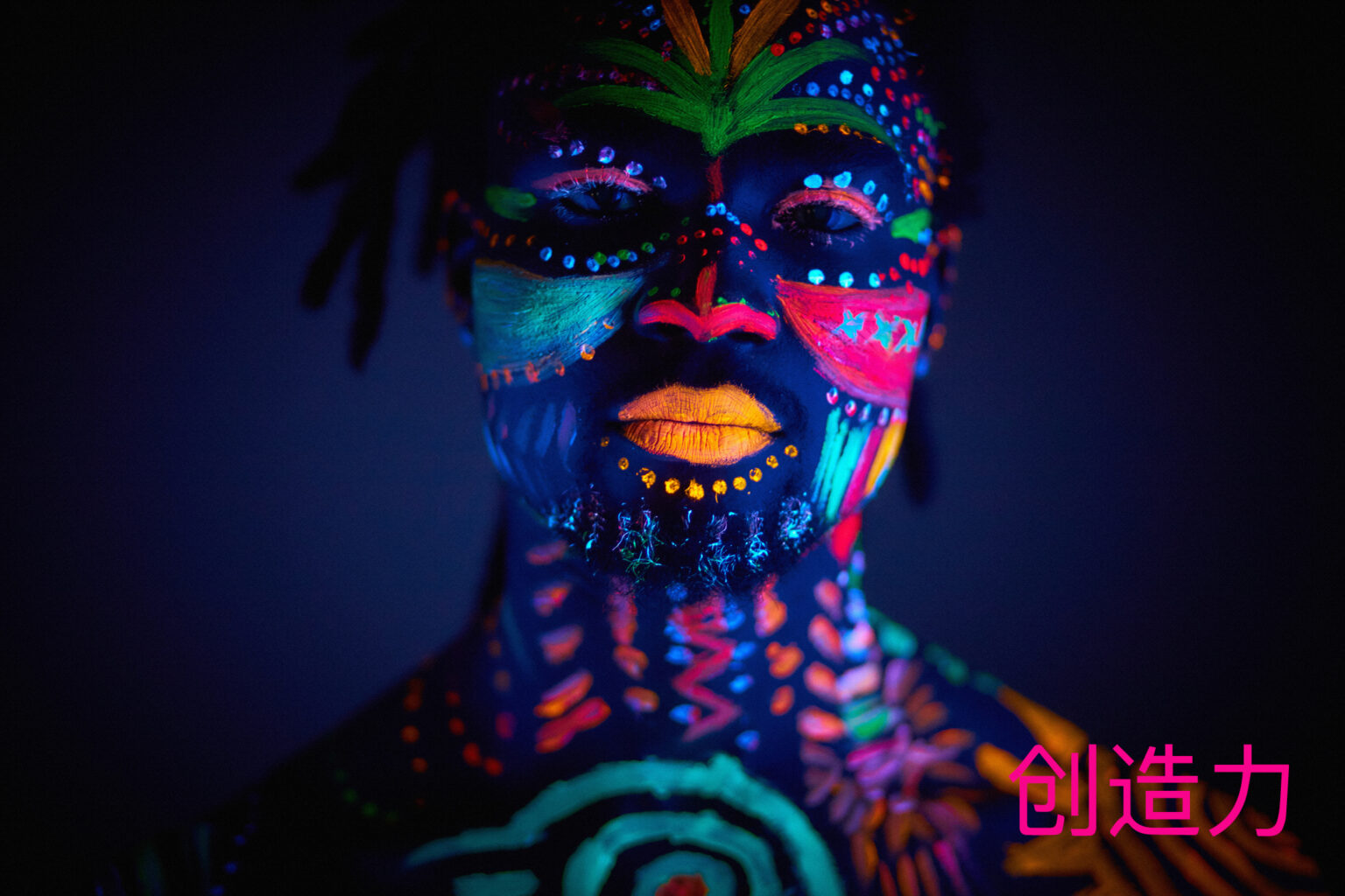 Granite Bay Graphic Design: Creativity: Image of a Man’s Face with Brightly Colored Face Paint in Black Light
