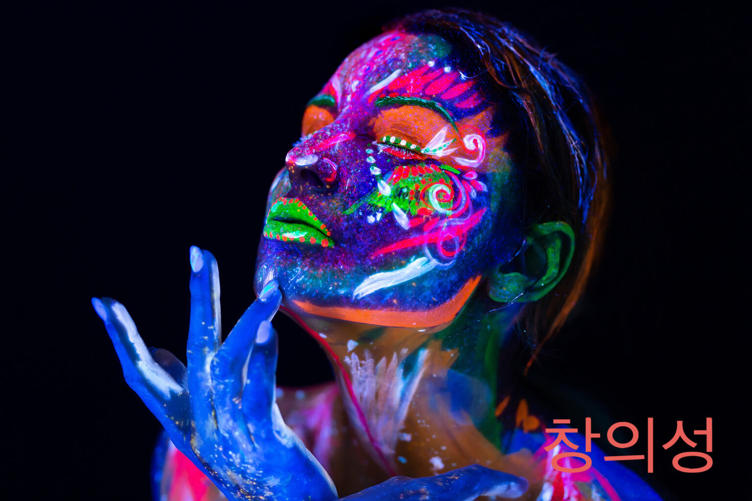 Granite Bay Graphic Design: Creativity: Image of a Woman’s Face with Brightly Colored Face Paint in Black Light