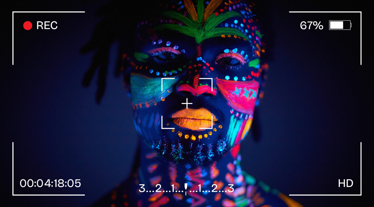 Granite Bay Graphic Design: Photography: Example of Portrait Photography: A Man’s Face with Brightly Colored Face Paint in Black Light